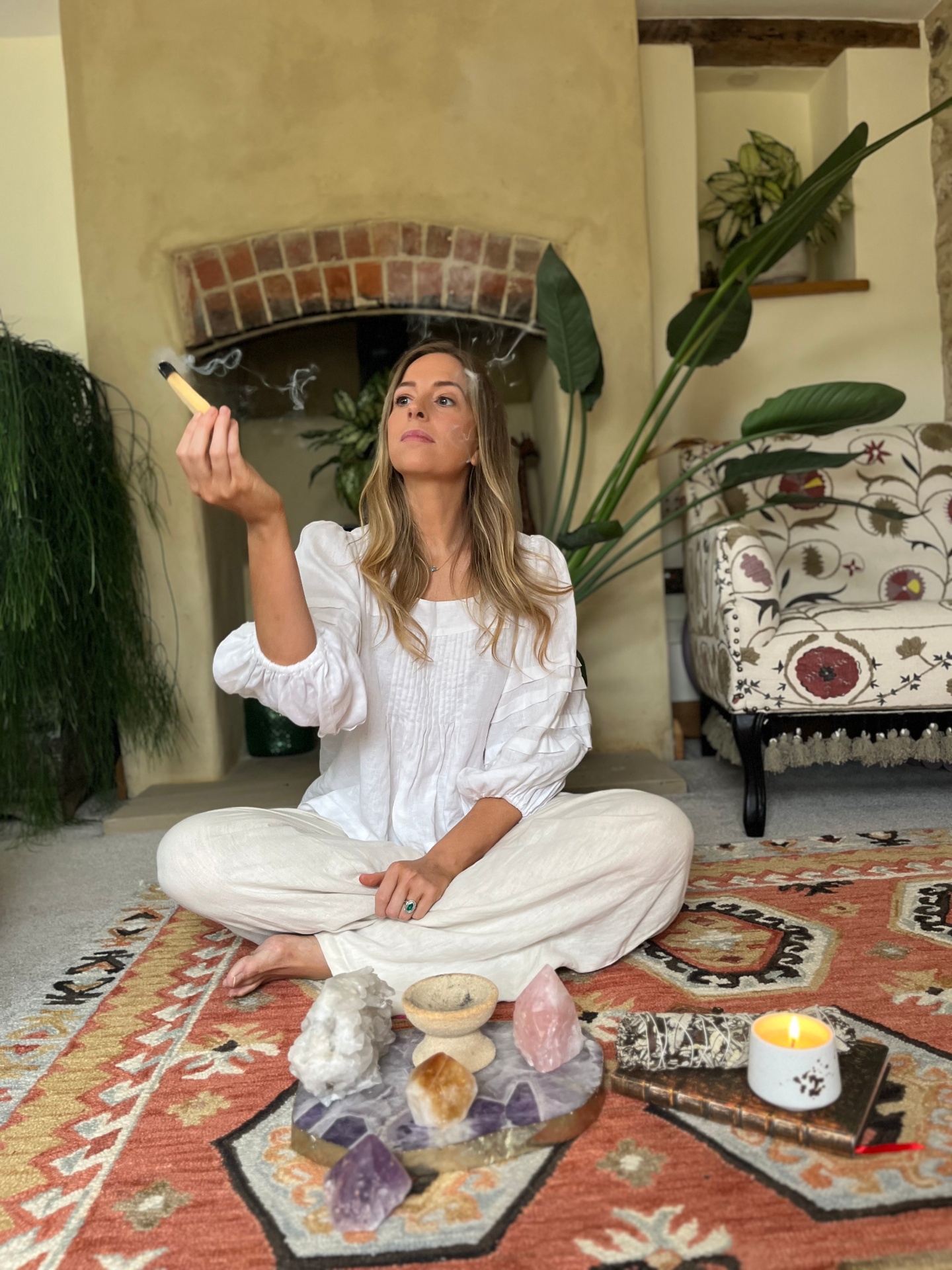 Kate Leach in a quiet ritual space holding incense